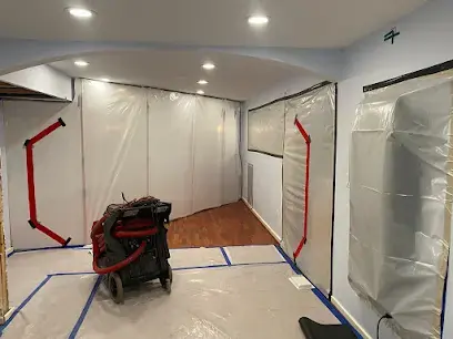Plastic containment and a dehumidifier set up in a hallway